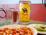 A bottle of tequila, shot glass, and nuts from La Casa de las Sirenas in Mexico City.