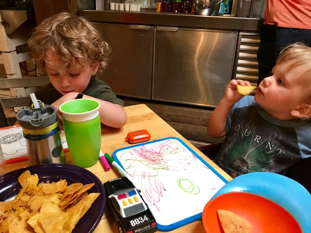 Two little boys eating in a restaurant 