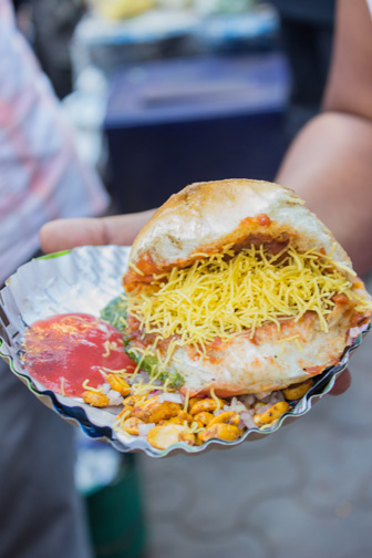 A street food called dabeli as found in Mumbai: spicy, seasoned boiled potatoes in bread.