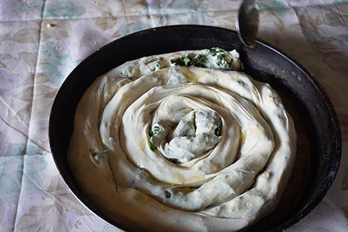 Burek, or pita, spiraled into a pan about to be cooking, in Bosnia