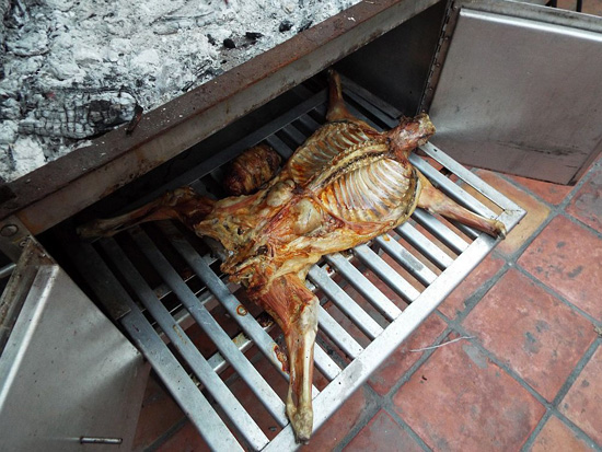 Cabrito, or goat, coming out of the caja china roasting box in Monterrey, Mexico.