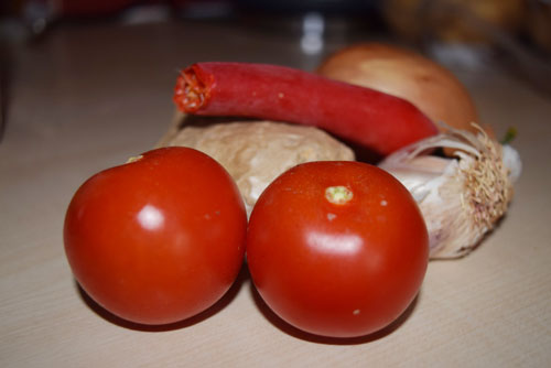 Ingredients for a Pakistani curry, including tomatoes, chilies, garlic and ginger