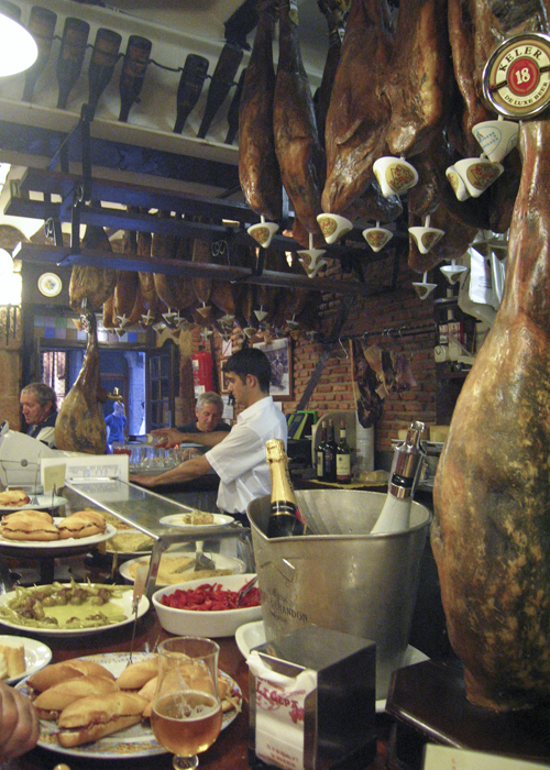 Legs of ham hanging above a pintxos bar in San Sebastian, Spain