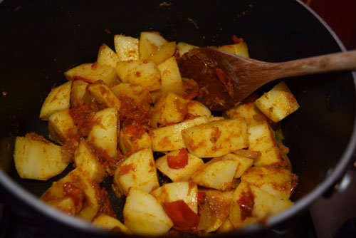 Chopped potatoes cooking in a Pakistani curry at home