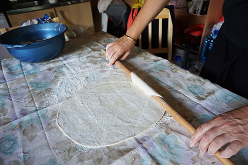 Rolling out dough for burek, or pita, in Bosnia and Herzegovina
