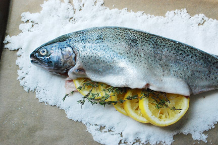 Stuffing the cavity of a sea bass with lemon and thyme.