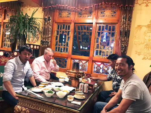 A tour guide with a small group at a restaurant in Tibet.