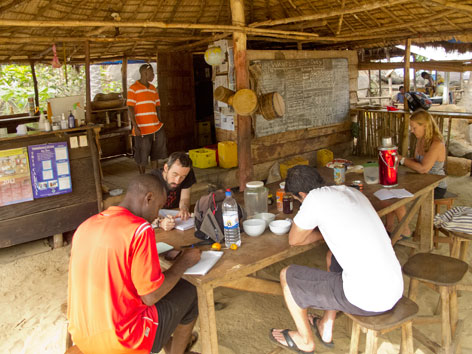 Guests at communal kitchen table at Tribewanted, Sierra Leone