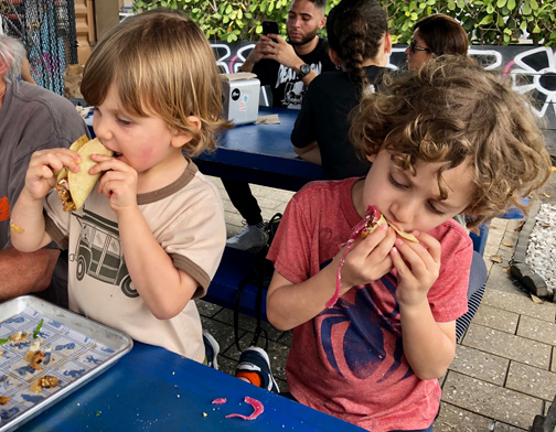 Two little boys eating tacos in Wynwood, Miami, Florida.