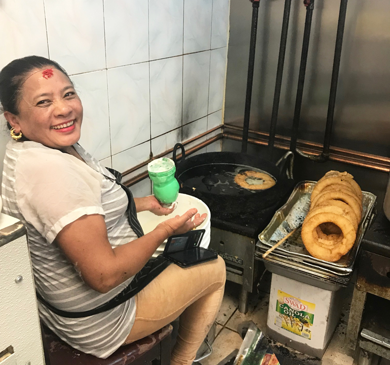 Nepali woman cooking sel roti in Queens restaurant