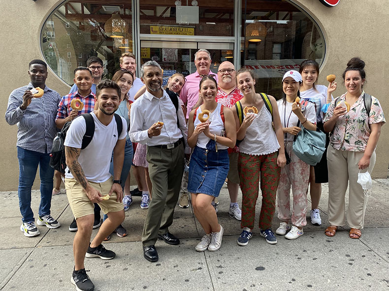 A university group poses for a picture outside a Colombian bakery on a food tour in Jackson Heights with Eat Your World.
