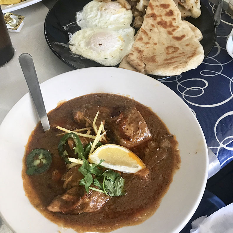 A bowl of chicken nihari with eggs and naan for breakfast at the Pelican Restaurant in Lake Worth, Florida