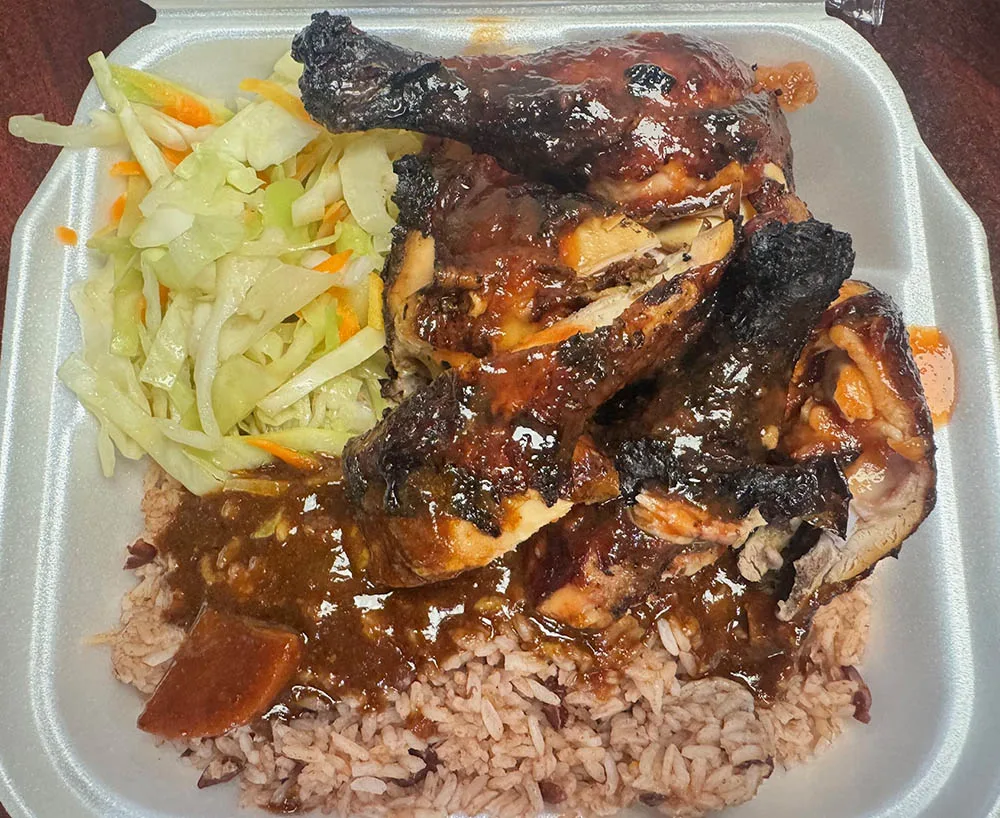 A plate of jerk chicken, rice, and salad from Reggae Jerk in Lake Worth, FL.