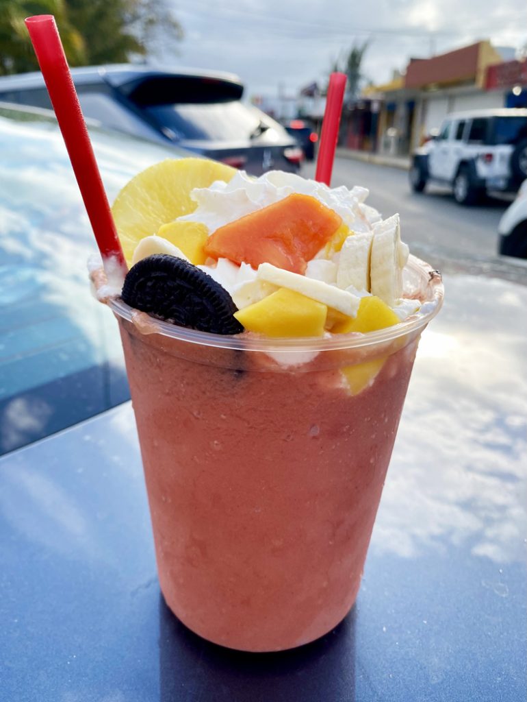 An oversize mixed-fruit batido, or smoothie, topped with fruit, whipped cream, and cookies, in Puerto Rico