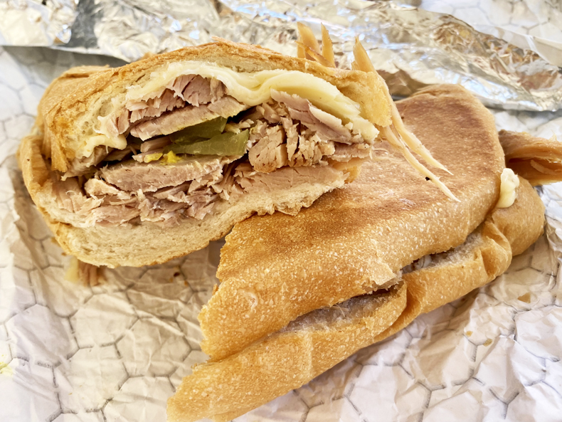 Pernil, or roast pork, sandwich with pickle and cheese from a cafe in Puerto Rico