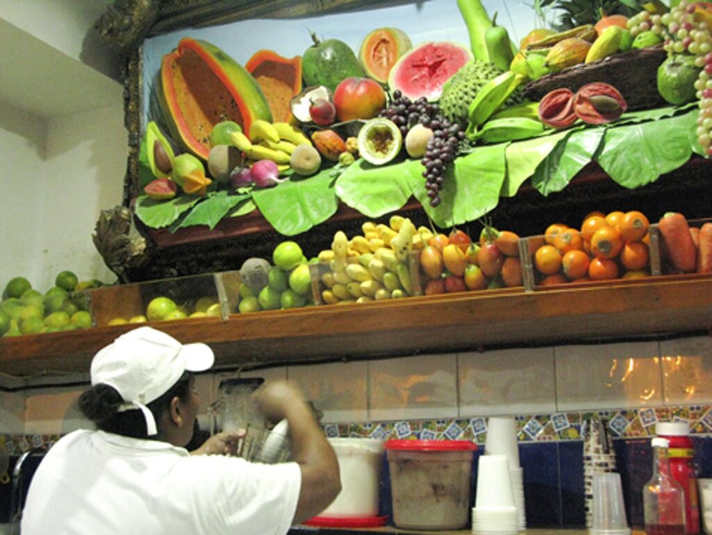 A Colombian woman making fresh jugos from La Esquina del Pan de Bono in Cartagena.
