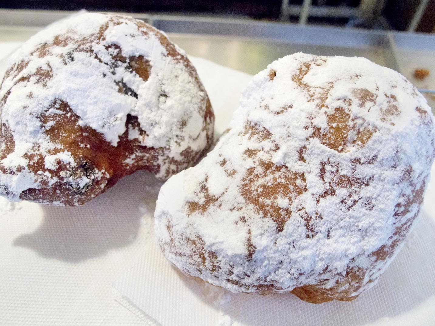 An olliebollen and a krentenbollen purchased on the street in Amsterdam, the Netherlands