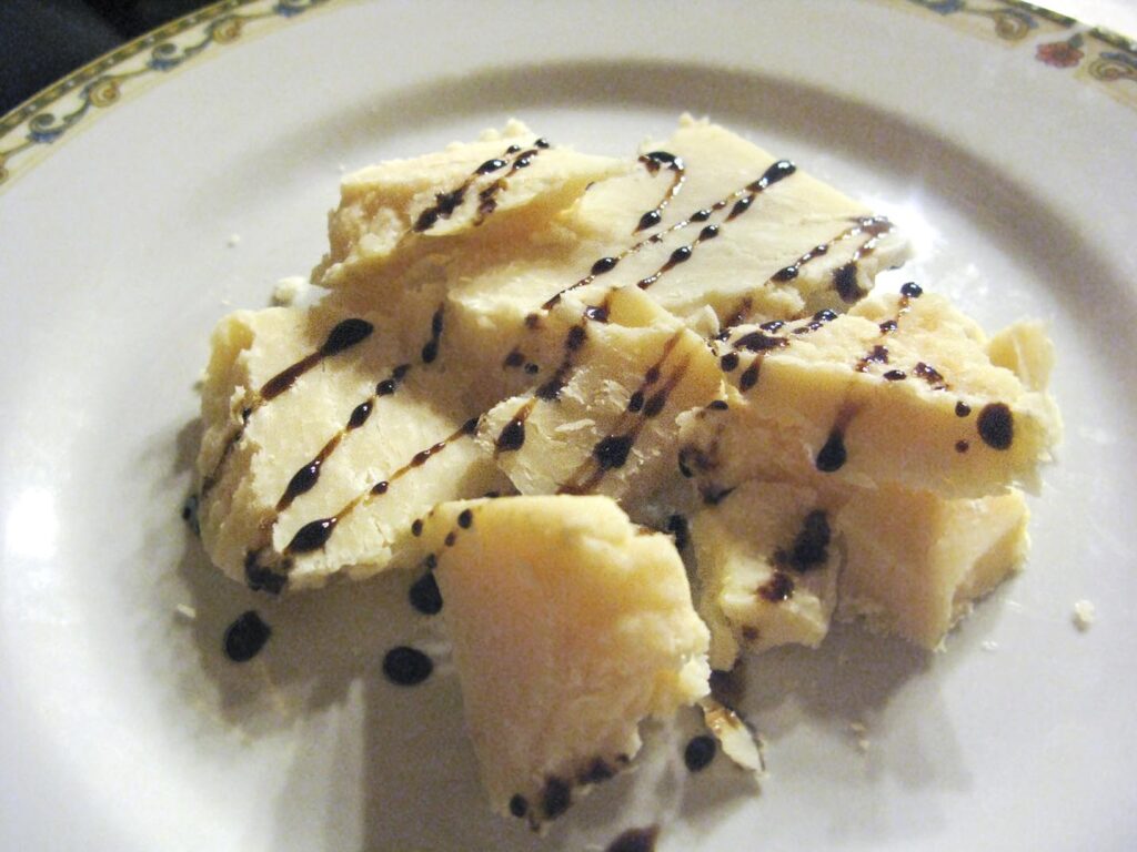 Hunks of Parmigiano-Reggiano cheese with a drizzle of balsamic vinegar from Trattoria Vigolante in Parma, Italy.