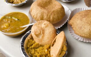 Bowls of bedmi aloo and nagori halwa from Shyam Sweets in Delhi, India.