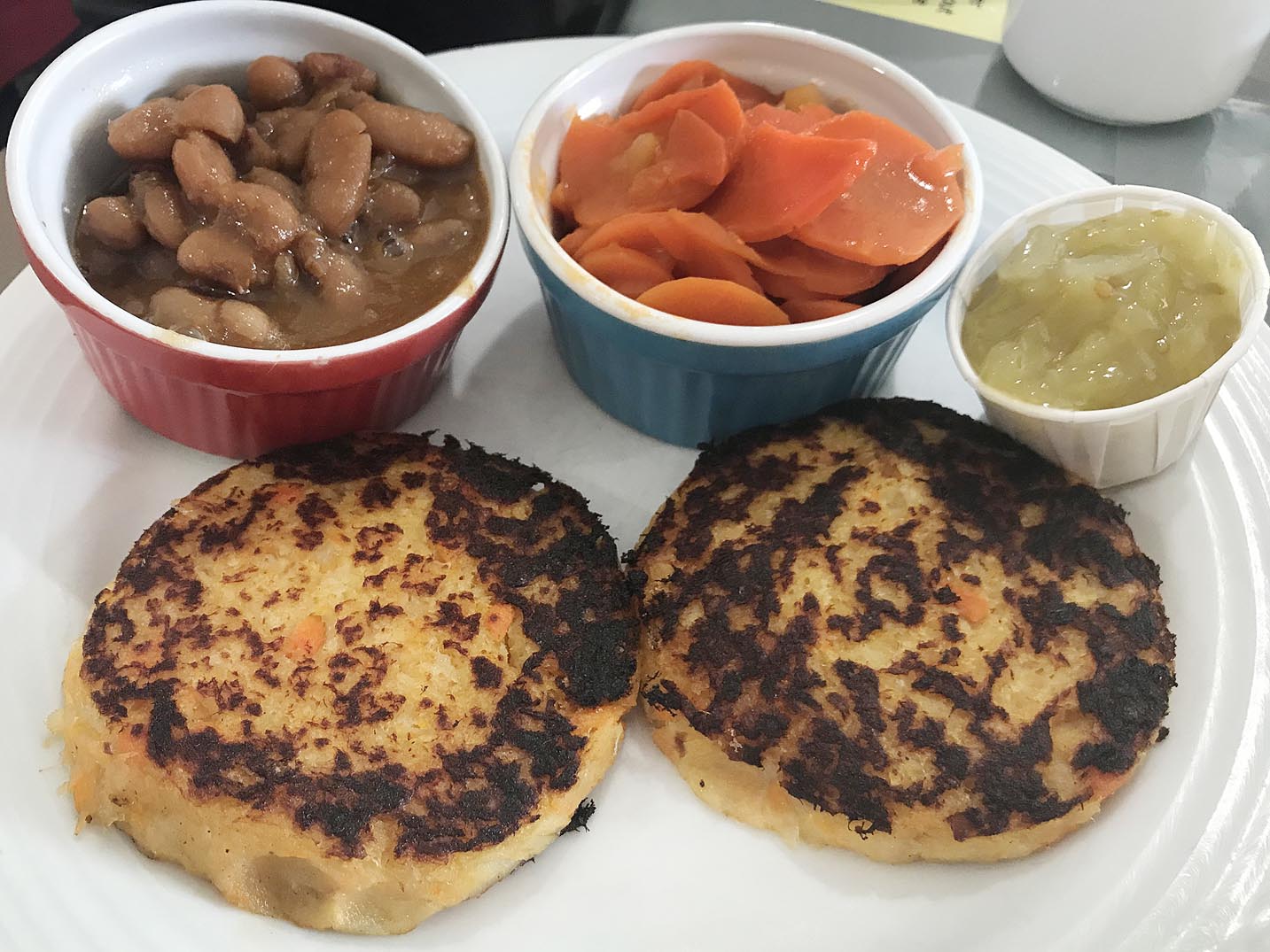 Acadian fish cakes with baked beans, chow-chow, and carrots in Nova Scotia.