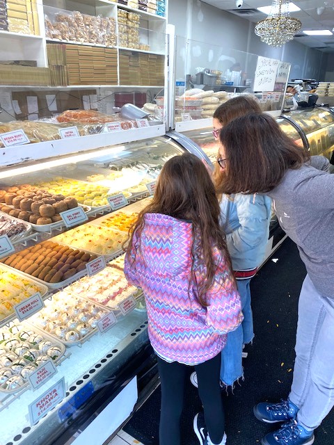 A family chooses Indian sweets to try on a world food tour for families in Jackson Heights, Queens.