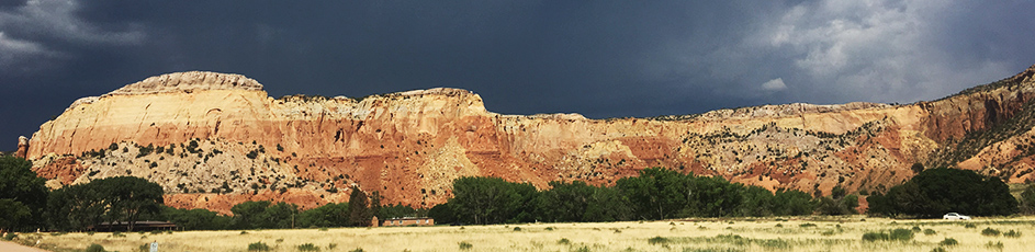 A panoramic of red mountains in New Mexico before a storm.